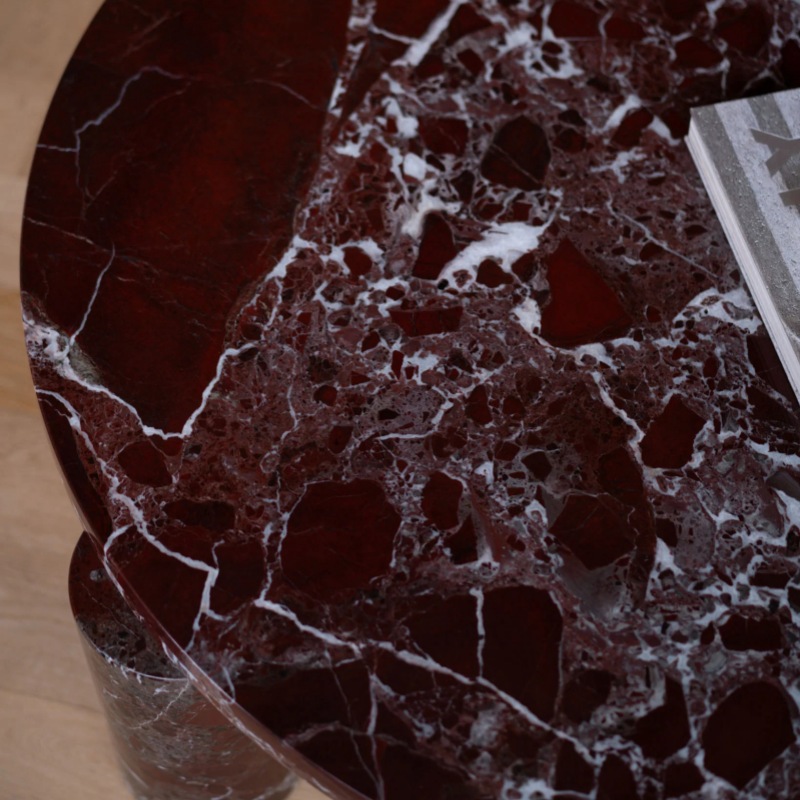 Close-up of burgundy marble texture on round coffee table - white veined natural stone detail