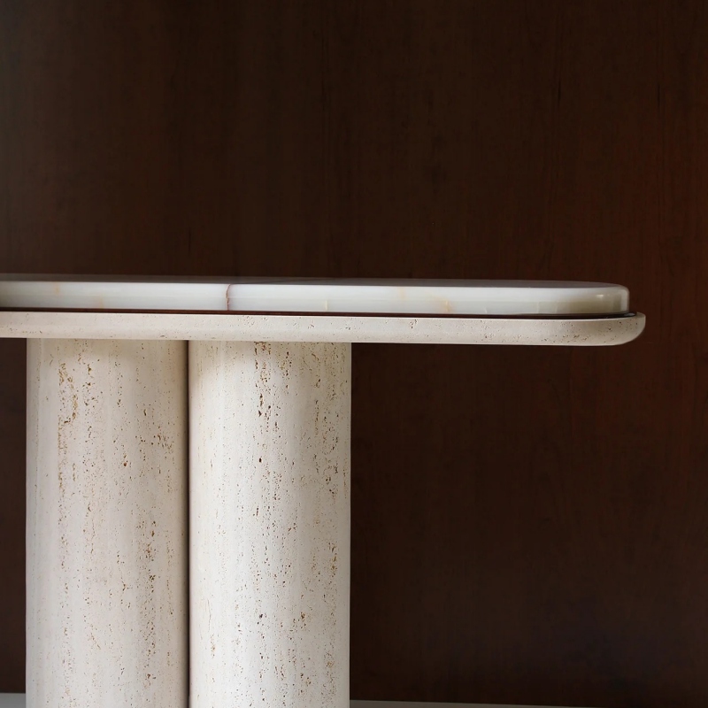 Close-up of beige travertine cylindrical bases on console table - natural porous stone texture