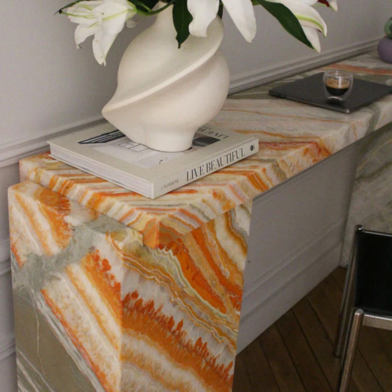 Close-up of Rainbow Onyx tabletop - layered stone vein detail with decor