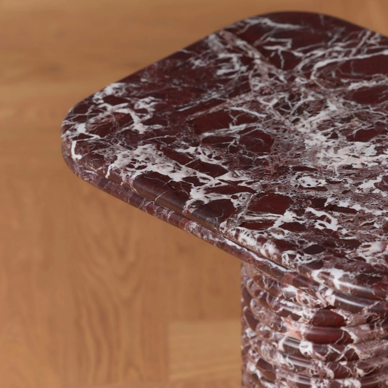 Close-up of Rosso Levanto marble tabletop on side table - natural veined stone edge detail