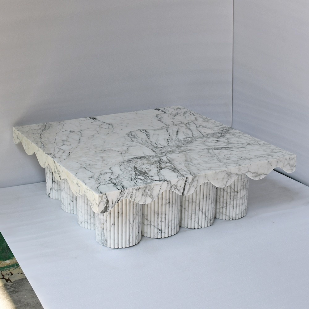 Close-up of white marble coffee table - grey veining, scalloped tabletop and fluted legs detail
