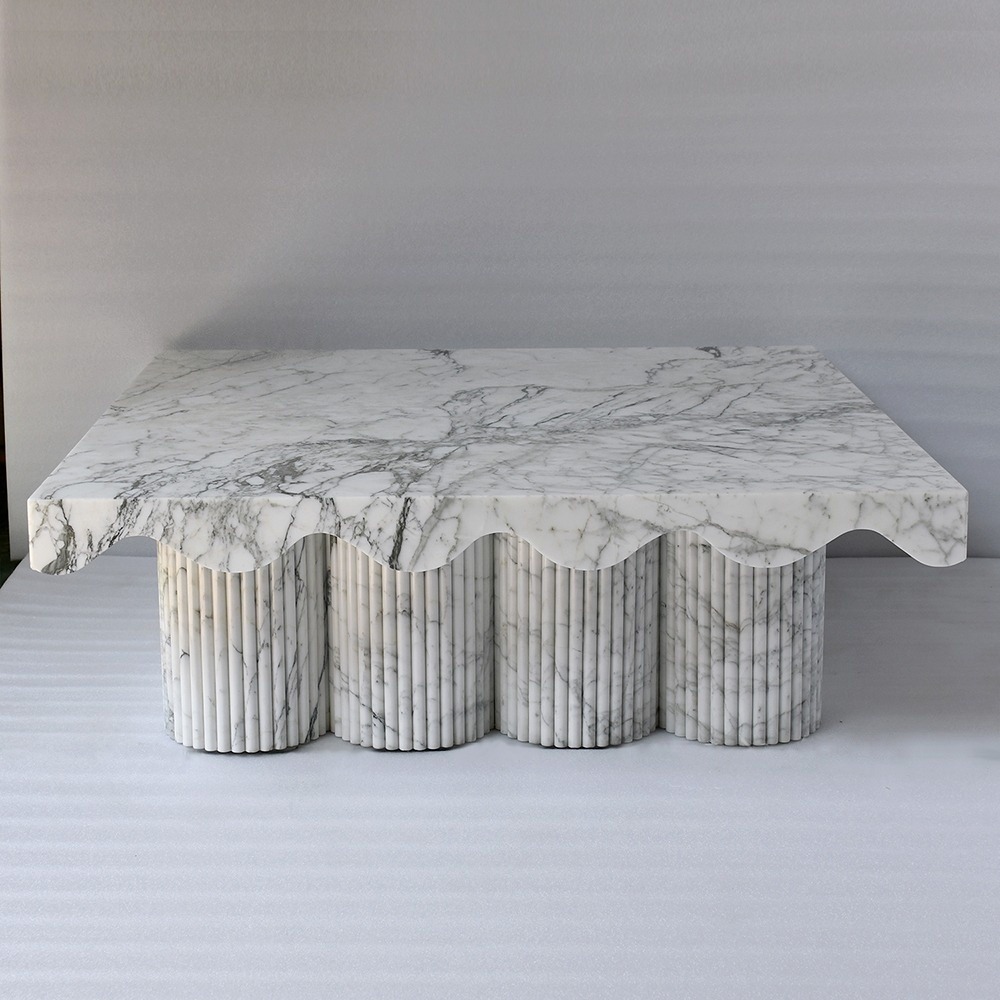 White marble coffee table with scalloped edge and fluted cylindrical legs